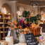 Decorative setup with flowers, candles, and a sign in a store setting.